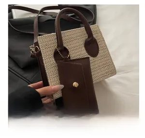 Detail of straw woven tote with brown leather handles and matching coin purse charm