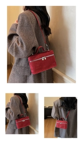 Macro detail of wine red suede box bag with heart zipper pull and matching shoulder strap