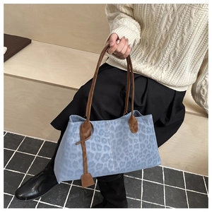 Close-up of blue leopard print tote bag with soft suede texture and leather handles
