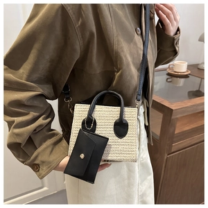 Detail of woven straw bag with black leather straps and mini pouch accessory