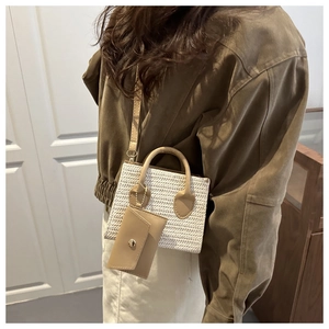 Detail of cream woven mini bag with brown handles and matching coin purse charm