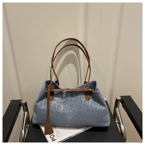 Détail du sac fourre-tout à imprimé léopard bleu clair avec lanières en cuir marron