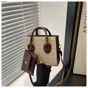 Detail of straw handbag with dark brown leather trim and matching small envelope pouch