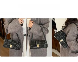 Detail of elegant black and gold tweed shoulder bag with polished metallic buckle