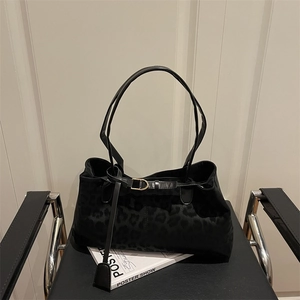 Grand sac cabas noir à imprimé léopard avec boucle dorée sur chaise pliante chic