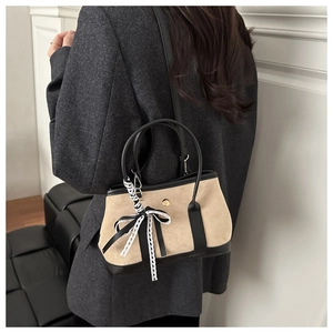 Detail of leopard texture bucket bag with leather trim and decorative lace ribbon