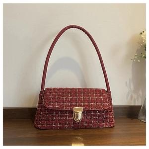 Detail of red tweed shoulder bag featuring a gold twist lock and elegant texture
