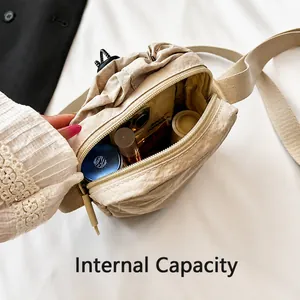 Detail view of mini nylon crossbody bag interior showing space for phone and makeup