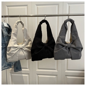 Détail de sacs à main en velours côtelé avec nœud en beige, noir et gris sur support
