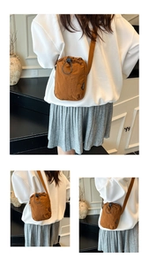 Detail of nylon crossbody water bottle bag with drawstring closure and fashion tag