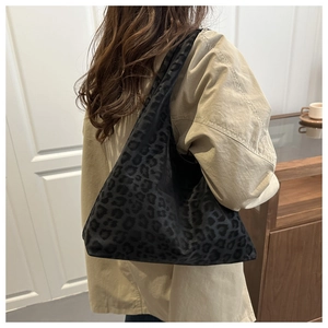 Fashionable leopard print shoulder bag worn by model in a minimalist interior setting