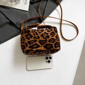 Pluche draagtas met luipaardprint, bruine riemen, metalen gesp en smartphone-referentie