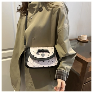 Détail du sac sous l'aisselle à motif de nœud floral avec pendentif en forme de cœur