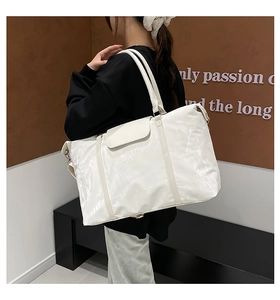 Detailaufnahme der weißen Reisetasche mit gefalteter Nylon-Textur und Doppel-Schultergurten