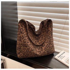 Detail of soft leopard print tote bag with large capacity on a modern black surface