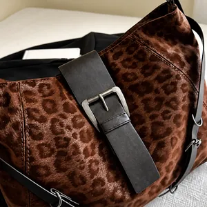 Close-up of leopard print satin fabric with large brown strap and matte metal buckle