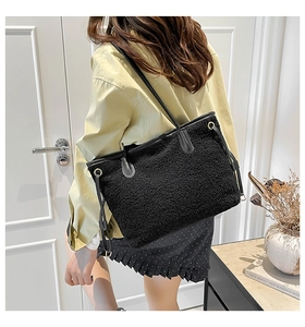 Detail view of black sherpa tote bag with leather straps and drawstring accents