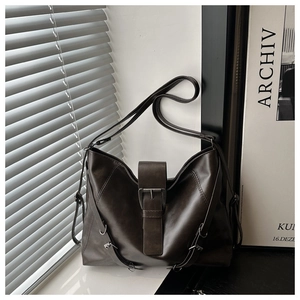 Detail of deep brown retro tote bag with matte leather finish and metal buckle strap
