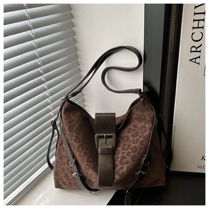 Close-up of leopard print suede tote bag featuring a vintage bronze buckle and wide strap