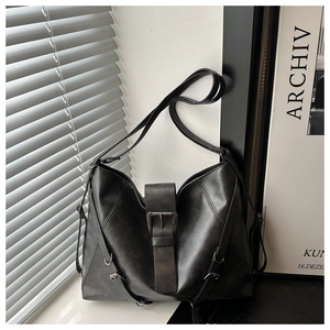 Close-up of black hobo bag showing retro leather texture and metal buckle detail