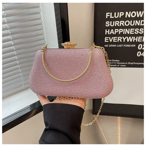 Dettaglio della pochette rosa glitterata con catena a serpente dorata e chiusura a gemma