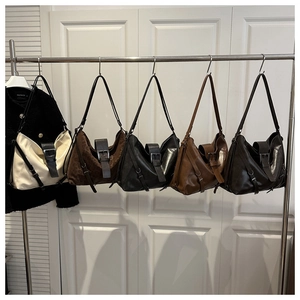 Various textured tote bags in leopard print and solid colors hanging on a metal rack