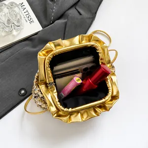 Macro view of gold sequin cloud bag interior showing space for phone and makeup items