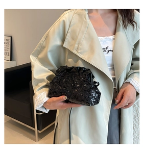 Detail view of a black sequin cloud bag with elegant pleated edges and long leather strap