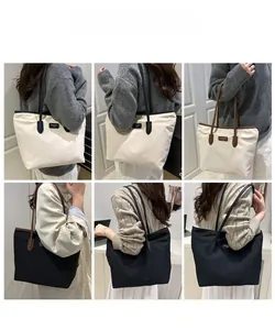 Detail view of large capacity tote bag worn as a shoulder bag in black and beige colors