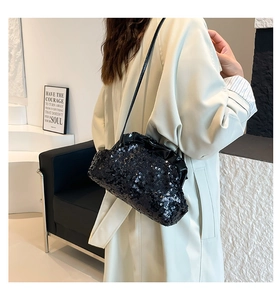 Detail of black sequined cloud bag featuring pleated design and thin shoulder strap
