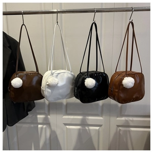 Minimalist square crossbody bags in four solid colors with white pompom charms