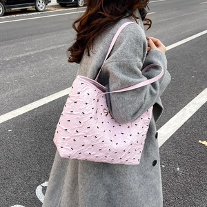 Sac fourre-tout rose à motifs nœuds noirs avec pendentif dans un style urbain chic