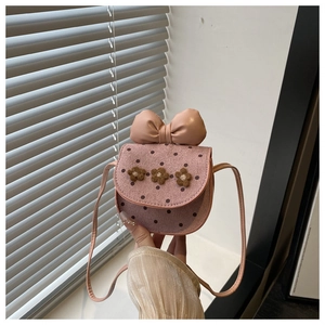 Detail of pink polka dot mini bag with floral accents and large leather bow