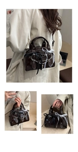 Dettaglio borsa in ecopelle marrone scuro con catene d'argento e fiocchi di pizzo