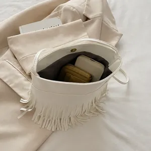 Vue intérieure du sac à bandoulière à franges blanches montrant la capacité de rangement