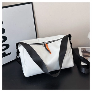 Close-up of white nylon messenger bag featuring black straps and orange leather zip puller