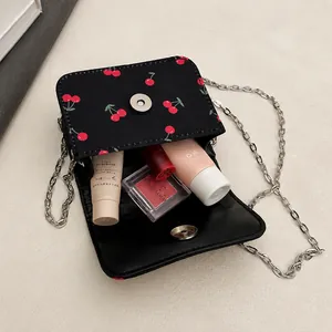Vue détaillée de l'intérieur du sac à bandoulière noir à motif cerise et chaîne