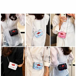 Mini sac à chaîne imprimé cerises en quatre couleurs porté par un mannequin avec sequins