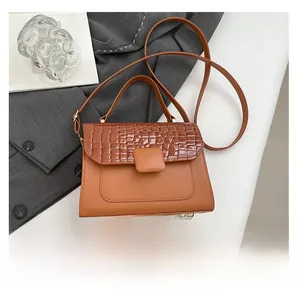 Detail of vintage brown crocodile texture handbag with phone for size reference