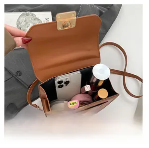 Interior view of brown leather bag showing capacity for phone and cosmetics
