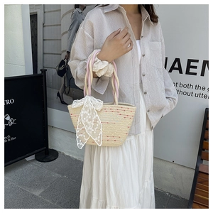 Detalle del bolso de paja tejido con puntos de colores y accesorio de pañuelo con encaje