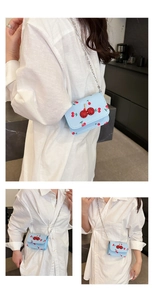 Détail du mini sac bleu clair à motif cerises avec cerise en paillettes et chaîne argentée