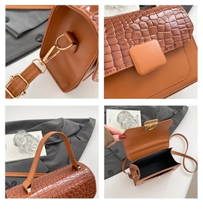 Detail of brown crocodile pattern handbag with golden hardware and spacious interior