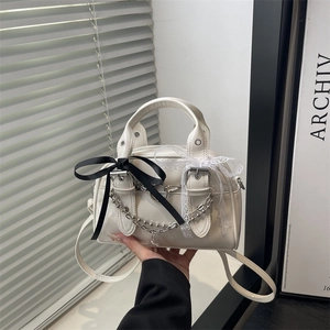 Weiße Boston-Tasche aus Kunstleder mit Metallketten und dekorativen Spitzenschleifen