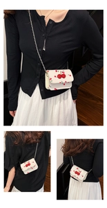 Gros plan du sac bandoulière crème avec cerises 3D et bandoulière en chaîne métal