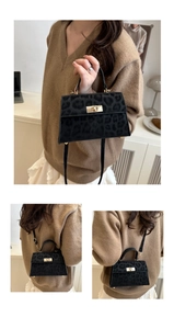 Detailed close-up of a leopard print crossbody bag with fuzzy texture and gold lock