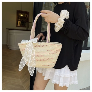 Detalle de bolso de paja tejido con lazo de encaje blanco y botón de perla elegante