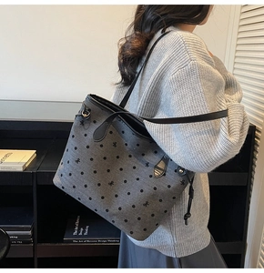 Détail du sac cabas à pois avec broderie nœud et bandoulière en cuir porté par un modèle