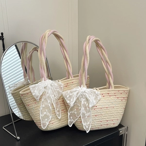 Handwoven straw tote bag with rainbow accents and white lace bow for beach vacation