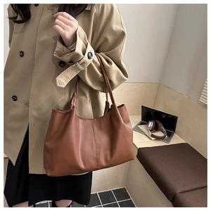 Bruine kunstleren shopper met verticale stiksels gestyled met een trendy trenchcoat